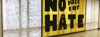 No place for hate sign on wall with signatures