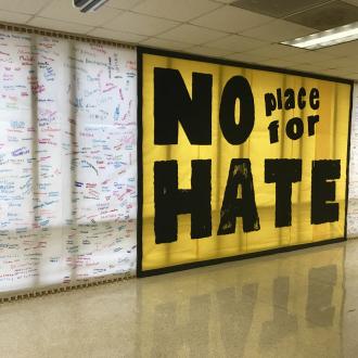 No place for hate sign on wall with signatures
