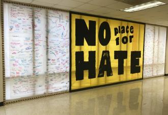 No place for hate sign on wall with signatures