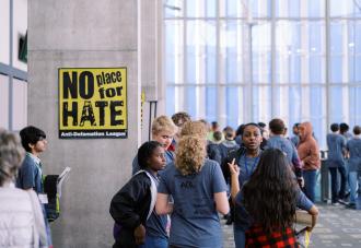 Students standing in hallway next to no place for hate sign